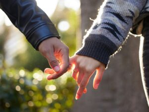 a close up of two people holding hands